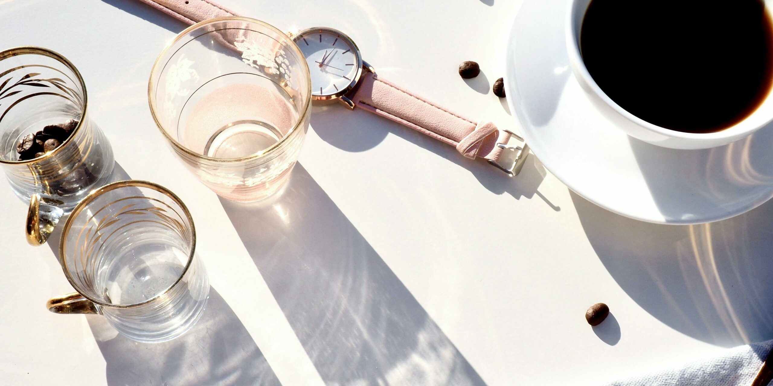 Orologio strumento base per il time tracking, tazza di caffè, bicchieri vuoti.