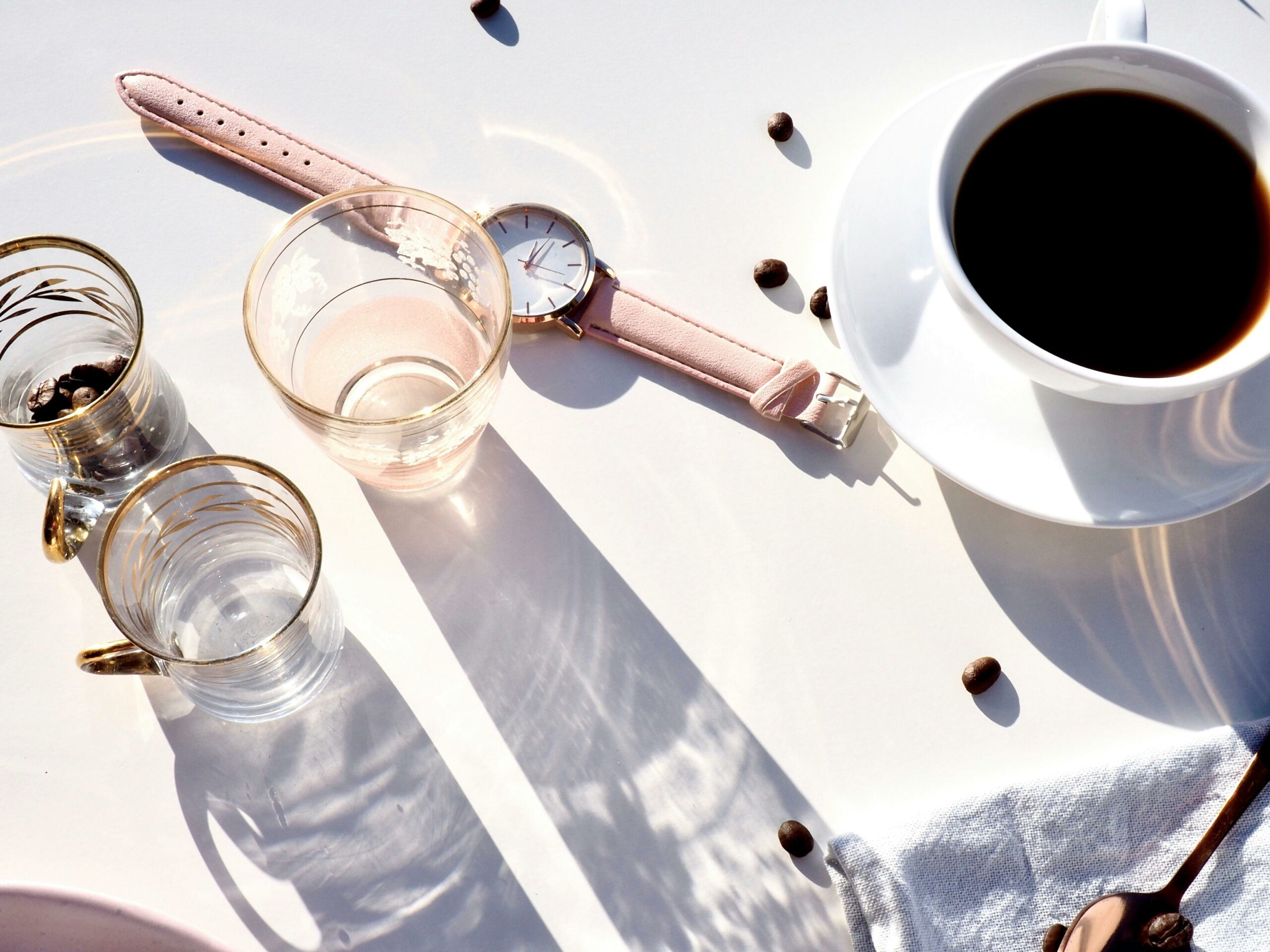 Orologio strumento base per il time tracking, tazza di caffè, bicchieri vuoti.